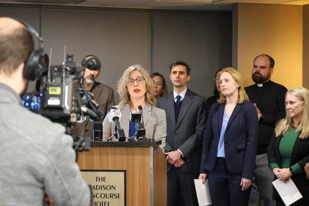 Tami Jackson, representing the Survival Coalition, speaks at the press conference, with other organization representatives behind her.