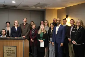 A group of advocates around the lectern at a press conference related to FoodShare funding. LOPPW is represented by Kacy Kostiuk and Pastor Andy Twiton.
