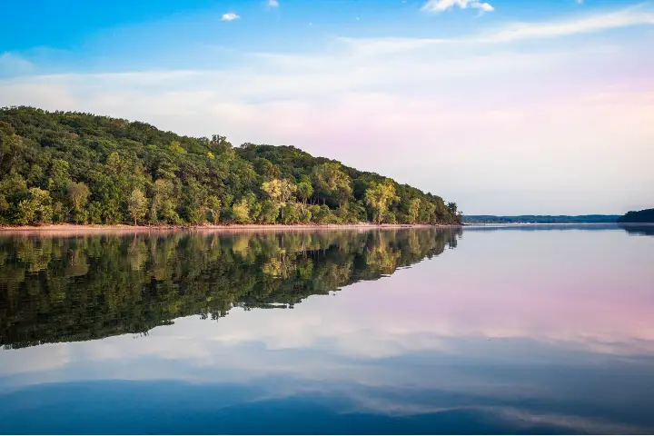 A photo of a lake with a forest in the background.