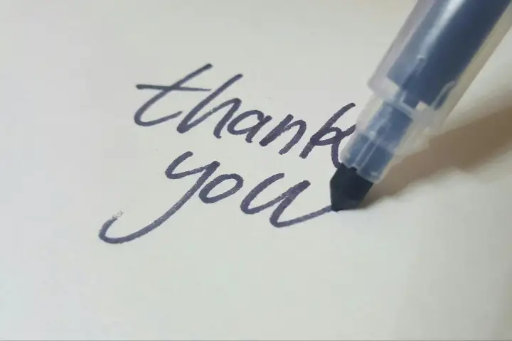 A person writing a thank-you card.
