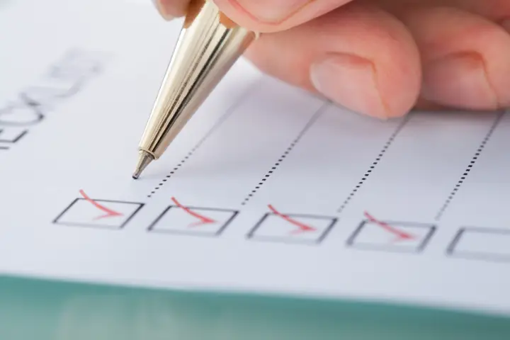 A person checking off boxes on a checklist.